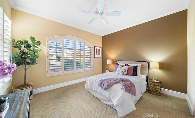 carpeted bedroom featuring ceiling fan, ornamental molding, and baseboards