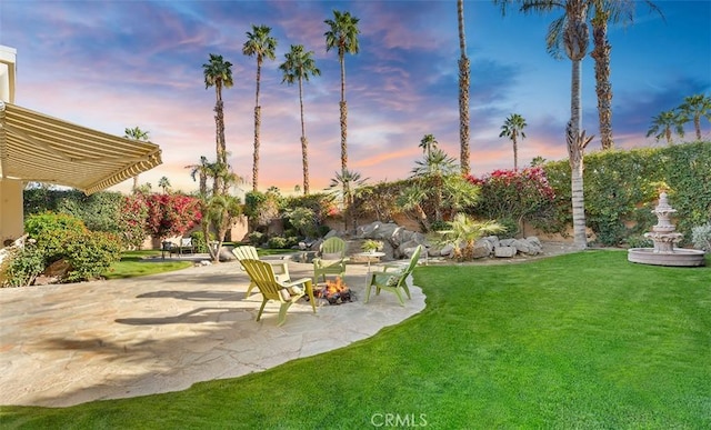 yard at dusk with a patio area and fence