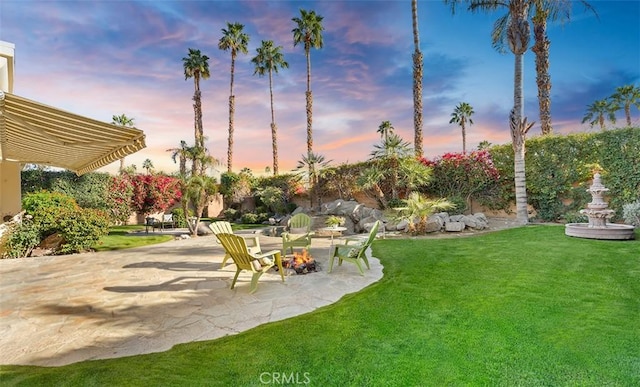 3 Mesquite Ridge Ln, Rancho Mirage, CA 92270 - yard at dusk featuring a patio, a lawn, and a fire pit