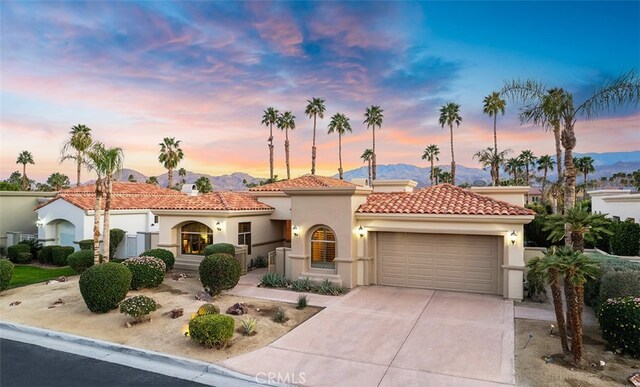 3 Mesquite Ridge Ln, Rancho Mirage, CA 92270 - mediterranean / spanish house featuring a garage, stucco siding, a tile roof, driveway, and a mountain view