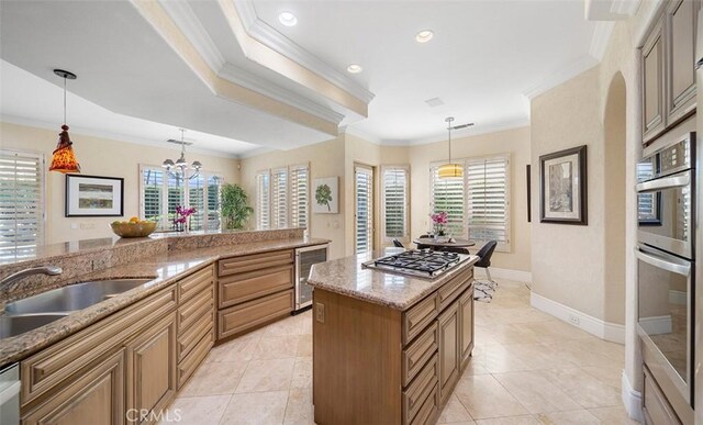 3 Mesquite Ridge Ln, Rancho Mirage, CA 92270 - kitchen featuring beverage cooler, appliances with stainless steel finishes, ornamental molding, plenty of natural light, and light stone countertops