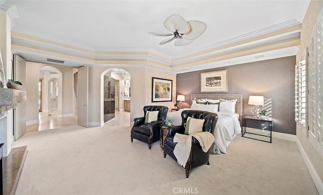 bedroom featuring a tray ceiling, arched walkways, carpet flooring, and ornamental molding