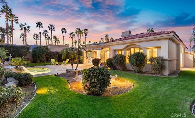 mediterranean / spanish-style house featuring a patio, a yard, and stucco siding