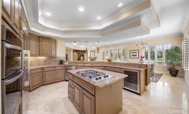 kitchen with wine cooler, stainless steel appliances, a raised ceiling, backsplash, and a peninsula