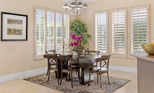 dining space featuring an inviting chandelier, plenty of natural light, baseboards, and tile patterned floors