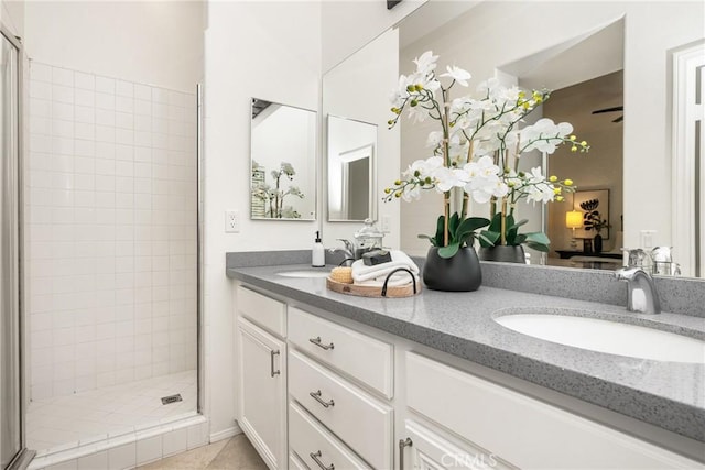 bathroom featuring tiled shower, vanity, and tile patterned flooring