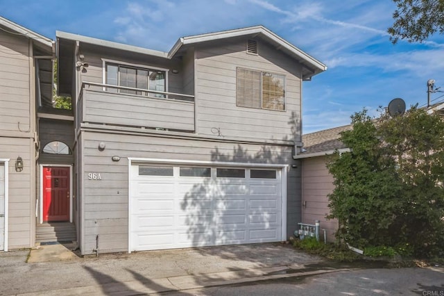 view of front of property with an attached garage and a balcony