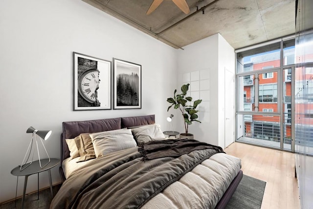 bedroom with expansive windows and wood finished floors