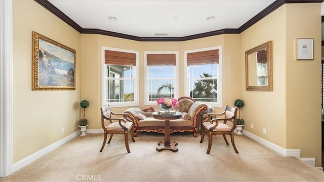 sitting room with light carpet, ornamental molding, and baseboards