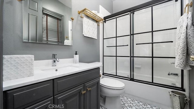 bathroom with combined bath / shower with glass door, vanity, and toilet