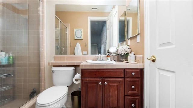 full bath featuring toilet, a shower stall, and vanity