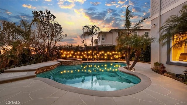 outdoor pool with a patio area and an in ground hot tub