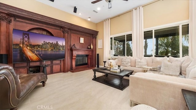 interior space with ceiling fan, a glass covered fireplace, and visible vents