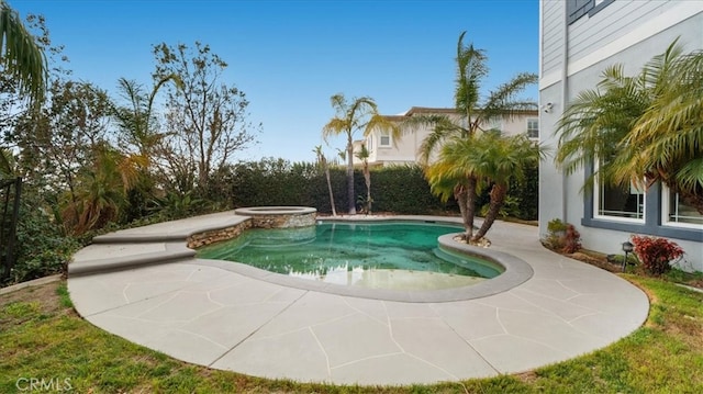 pool with an in ground hot tub and a patio area