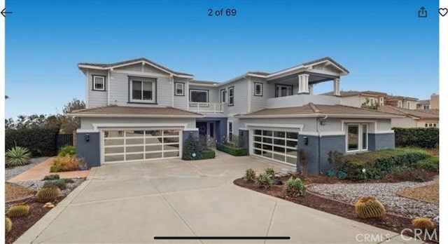 view of front of house with a garage, a balcony, and driveway