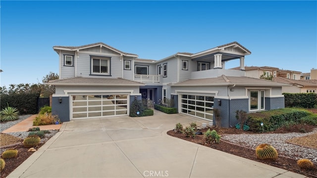 view of front of property featuring brick siding, driveway, a balcony, and an attached garage