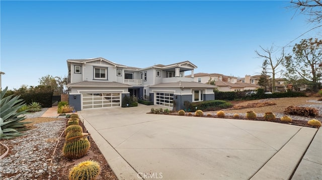 view of front of property featuring concrete driveway, an attached garage, fence, and a residential view