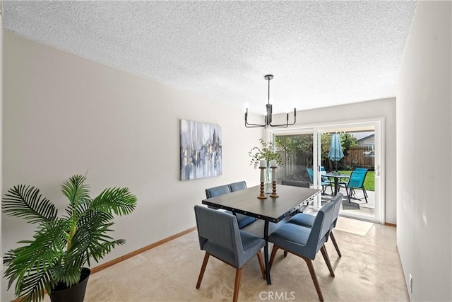 dining area with a textured ceiling, baseboards, and an inviting chandelier