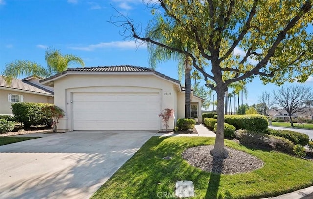 ranch-style home with driveway, an attached garage, and stucco siding