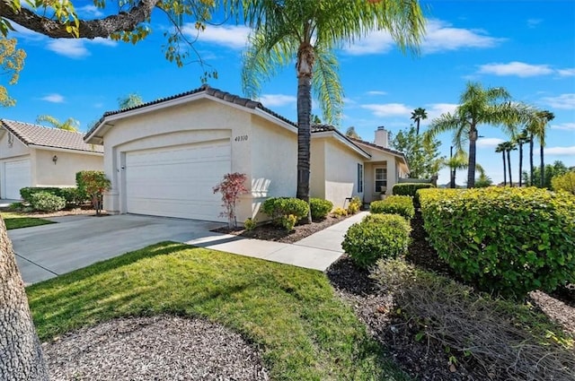 view of property exterior with a garage, driveway, a chimney, and stucco siding