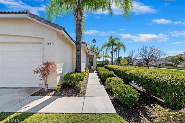 view of property exterior with an attached garage and stucco siding