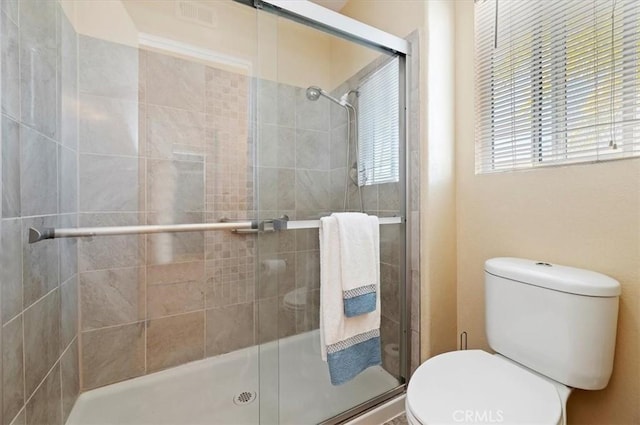 bathroom with toilet and a shower stall