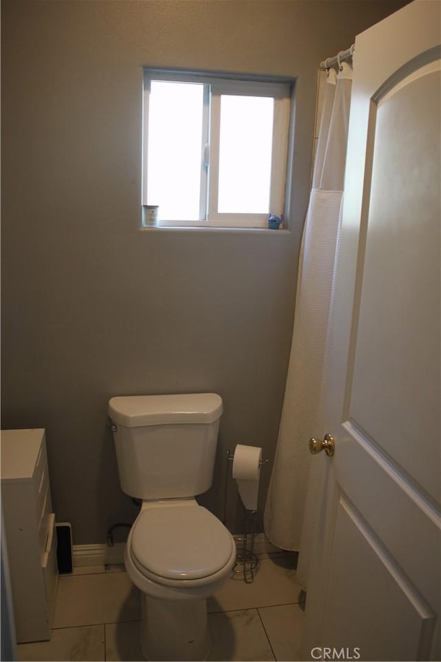 full bathroom with baseboards, toilet, and tile patterned floors