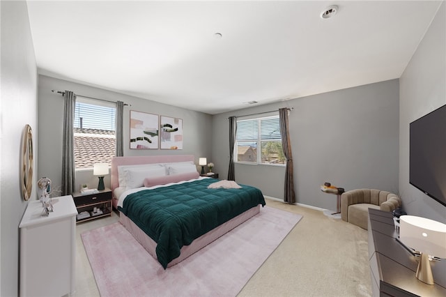 bedroom featuring light carpet and baseboards