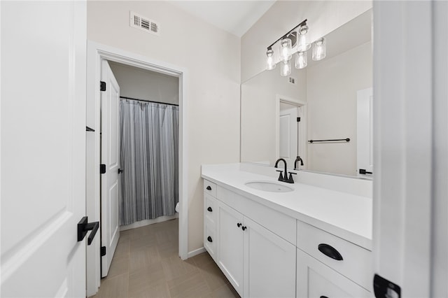 bathroom featuring toilet, vanity, and visible vents