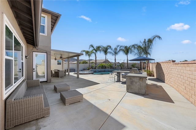 view of patio with an outdoor kitchen, a fenced in pool, ceiling fan, a fenced backyard, and outdoor lounge area