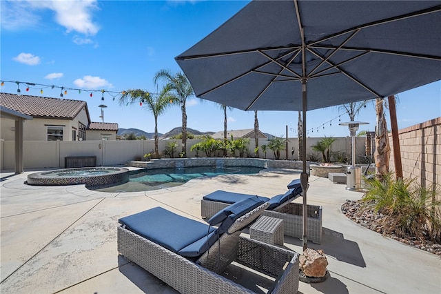 view of swimming pool with a patio, a pool with connected hot tub, a fenced backyard, and a mountain view