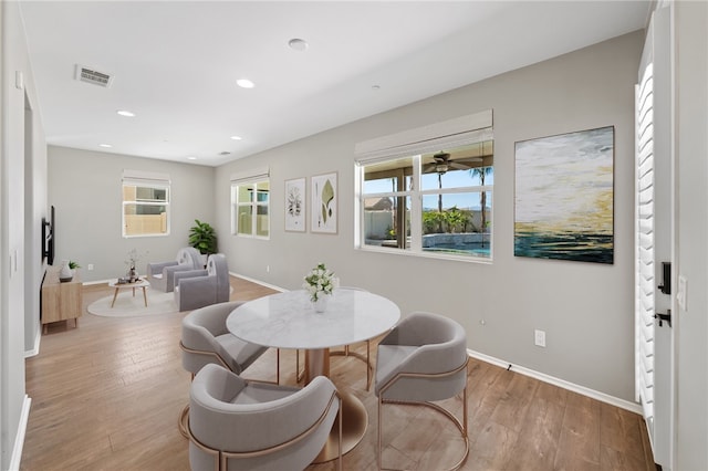 dining room featuring baseboards, wood finished floors, and a healthy amount of sunlight