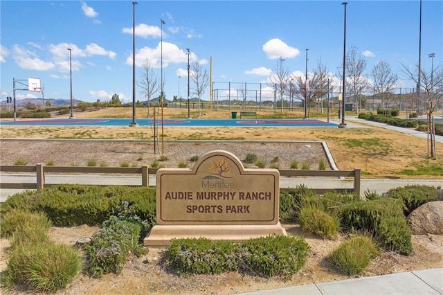 view of home's community featuring community basketball court and fence