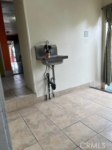 hallway featuring tile patterned floors and baseboards