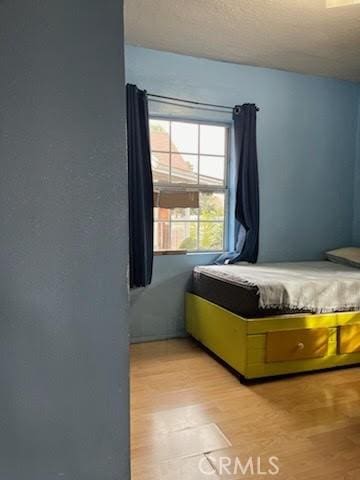 bedroom with light wood-style flooring and a textured ceiling