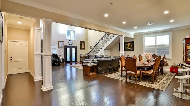 interior space with crown molding, dark hardwood / wood-style flooring, and decorative columns