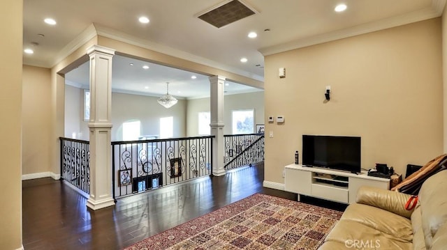 living room with crown molding, dark wood-type flooring, and decorative columns