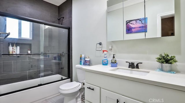 full bathroom with vanity, toilet, and combined bath / shower with glass door