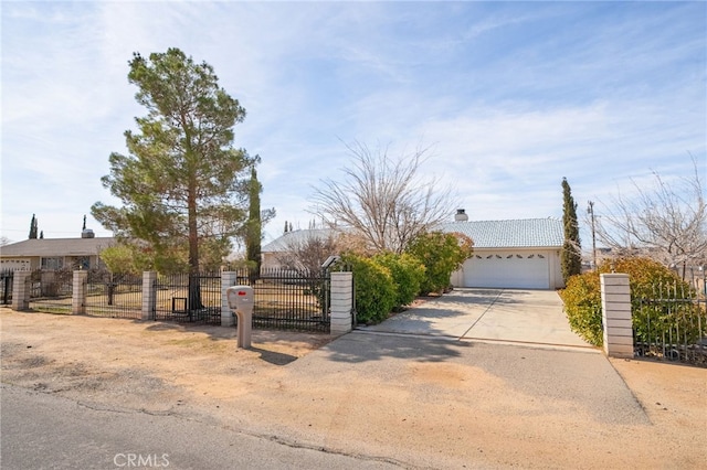 view of front of property featuring driveway, stucco siding, a chimney, a tile roof, and fence private yard