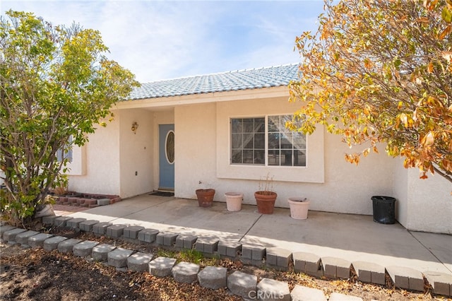 exterior space with a patio area, stucco siding, and a tile roof