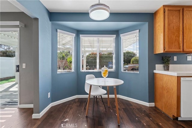 dining space with baseboards and dark wood finished floors