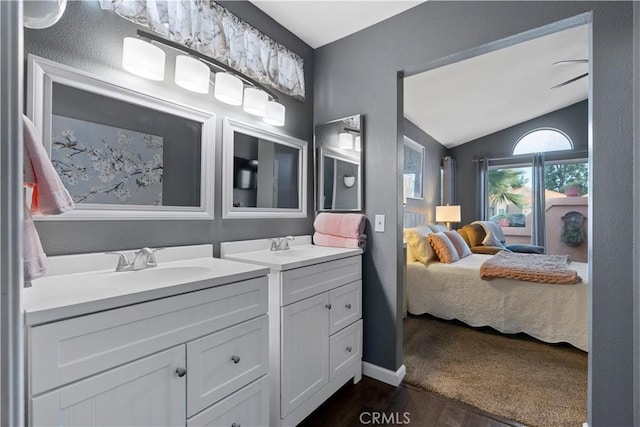 ensuite bathroom with lofted ceiling, two vanities, a sink, ensuite bath, and wood finished floors