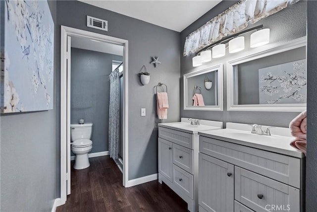 full bathroom featuring baseboards, visible vents, toilet, wood finished floors, and vanity