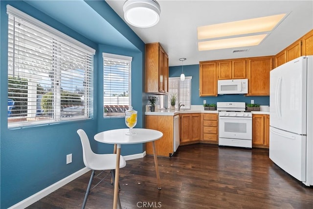 kitchen with dark wood finished floors, light countertops, visible vents, white appliances, and baseboards