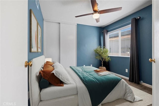 bedroom with ceiling fan, a closet, baseboards, and carpet flooring