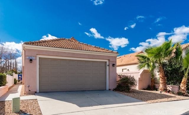 mediterranean / spanish-style house with fence, a tiled roof, and stucco siding