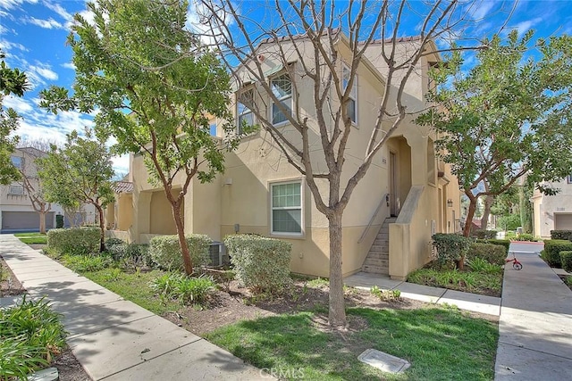 view of side of property with stairs and stucco siding