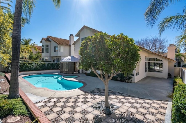 outdoor pool with fence and a patio