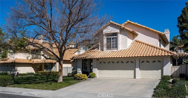 mediterranean / spanish house with a garage, concrete driveway, a chimney, fence, and stucco siding