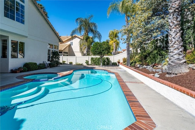 view of swimming pool featuring fence private yard and a pool with connected hot tub